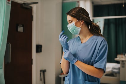 female-nurse-with-mask-putting-gloves
